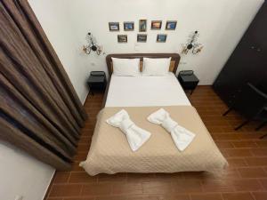 a bedroom with a bed with two ties on it at Alice Maisonette & Studios in Adamantas
