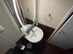 a bathroom with a white sink and a mirror at Alice Maisonette & Studios in Adamantas