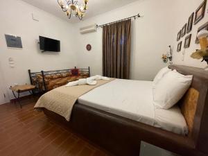 a bedroom with a large bed and a television at Alice Maisonette & Studios in Adamantas