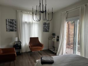 a bedroom with a bed and a chair and a chandelier at Sweet Home in Toronto