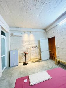 a room with a white brick wall and a table at May’s house Nhà của Mây in Hanoi
