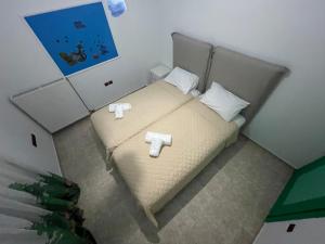 a small bedroom with a bed with two towels on it at Alice Maisonette & Studios in Adamantas
