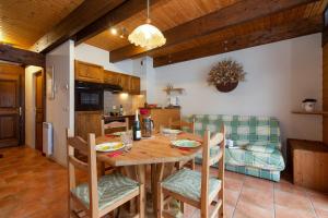 アルジェンティエールにあるChalet Résidence Chantey Mourry 6 - Happy Rentalsの木製のテーブルと椅子のあるキッチンとダイニングルーム