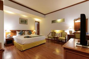1 dormitorio con 1 cama, escritorio y TV en Oscar Saigon Hotel, en Ho Chi Minh