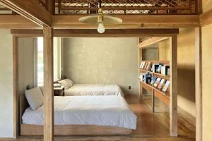 1 dormitorio con 2 camas y estante para libros en Miyakojima - House - Vacation STAY 77627v, en Sawada