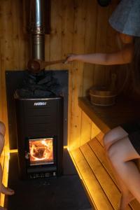 a stove with two people cooking in a room at 寝室から一望できる阿蘇山の絶景!!築200年の歴史ある米蔵をリノベーションした一棟貸しの宿 in Bōchū