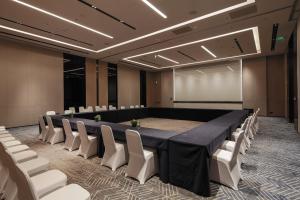 a conference room with a long table and white chairs at AC Hotel by Marriott Chengdu North in Chengdu