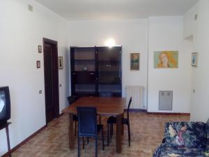 a dining room with a wooden table and chairs at Appartamenti Vista Gransasso in LʼAquila