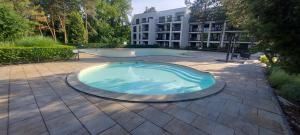 a large swimming pool in a courtyard with a building at Apartmán GIGI Rezort Linea in Piešťany