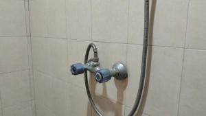 une douche avec un tuyau dans une salle de bain dans l'établissement RedDoorz at Jalan Sam Ratulangi Manado, à Manado