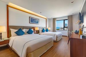 ダナンにあるPavilion Hotel Da Nangのベッド2台と窓が備わるホテルルームです。
