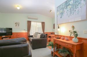 a living room with a couch and a tv at Silver Birches Holiday Village - Unit 3 in Bright