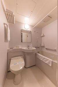 uma casa de banho com um WC e um lavatório em Okinawa Hotel em Naha