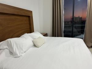 a bedroom with a white bed with a view of a city at Departamento en Mazatlán in Mazatlán +14 photos
