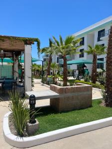 a park in front of a building with palm trees at Departamento en Mazatlán in Mazatlán