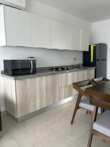 a kitchen with a counter with a microwave and a refrigerator at Departamento en Mazatlán in Mazatlán