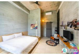 a bedroom with a white bed and a television at 隱月民宿 in Hengchun South Gate +4 photos