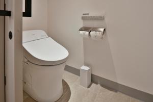 baño con aseo blanco en una habitación en Lequ Okinawa Chatan Spa ＆ Resort, en Chatan