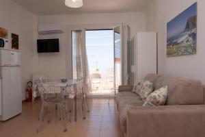 a living room with a couch and a table at Appartamento Conturrana Sul Mare in San Vito lo Capo
