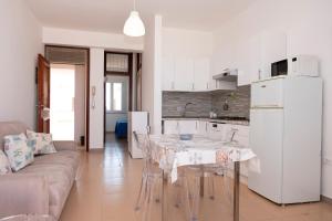 une cuisine et un salon avec une table et un canapé dans l'établissement Appartamento Conturrana Sul Mare, à San Vito Lo Capo 9 autres photos