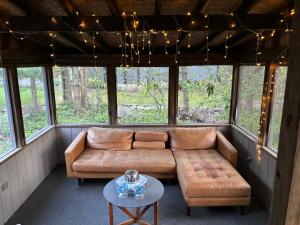 ein Wohnzimmer mit einem Sofa und einem Tisch in der Unterkunft Oceans - KING BED Cabin Loft & Fireplace in Tobyhanna