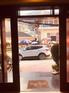 Vista de un coche blanco aparcado en un estacionamiento en Ba Liên Hotel Sapa - by Bay Luxury, en Lào Cai