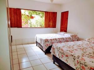a room with two beds and a window at Casa Rosa Chá em Lençóis in Lençóis