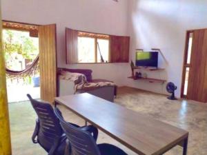 a living room with a wooden table and chairs at Casa Rosa Chá em Lençóis in Lençóis