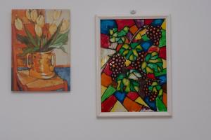 a painting and a painting of a vase with a plant at Appartamento Conturrana Sul Mare in San Vito lo Capo