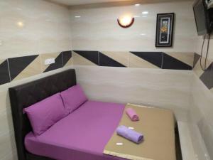 a couch with purple cushions in a room at ARK Malacca Hotel in Malacca