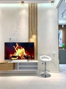 a fireplace in a living room with a fire at - Daniels Suite - Modern&Central - in Tashkent
