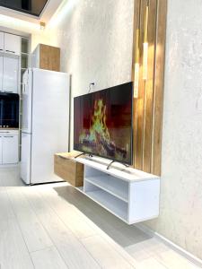 a kitchen with a refrigerator and a fire in the fireplace at - Daniels Suite - Modern&Central - in Tashkent