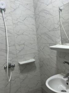 a white bathroom with a sink and a shower at Hotel Group in Cairo