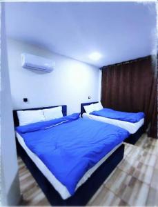 una camera con due letti con lenzuola blu di Hotel Group a Il Cairo