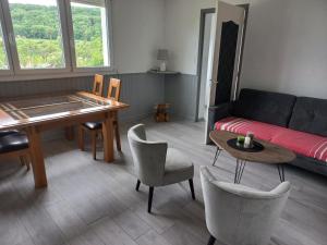 a living room with a couch and a table and chairs at Gite des forets in Trésauvaux