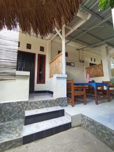 a patio of a house with a table and benches at Pedek Homestay in Praya