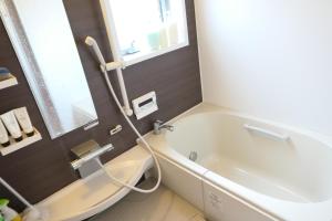 Nishiharamura阿蘇熊本 木の香の家 OMOYA - Aso Kumamoto Airport Timber House "KONOKA NO IE OMOYA"的带浴缸和水槽的浴室