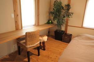 Nishiharamura阿蘇熊本 木の香の家 OMOYA - Aso Kumamoto Airport Timber House "KONOKA NO IE OMOYA"的一间有桌子、椅子和床的房间
