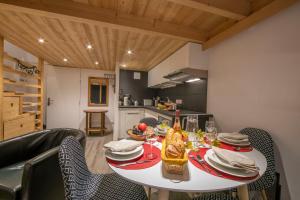 une salle à manger avec une table et des chaises blanches dans l'établissement Résidence Grand Roc - Ancolies 207 - Happy Rentals, à Chamonix-Mont-Blanc