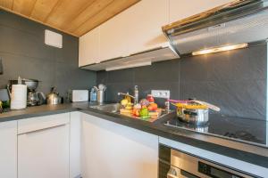 - une cuisine avec un évier et des fruits sur un comptoir dans l'établissement Résidence Grand Roc - Ancolies 207 - Happy Rentals, à Chamonix-Mont-Blanc