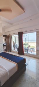 um quarto com uma cama e uma grande janela em Blue Pearl Beach Guest House em Māvalli