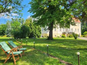 grupa krzeseł w trawie przed domem w obiekcie Pałac Henryków w mieście Szprotawa