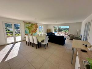 een woonkamer met een tafel en een bank bij Villa l'Esquirol with view and pool in Roquebrun