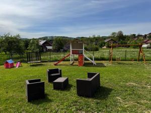 a park with a playground with a swing at Casa Croitoru Maramureş in Onceşti