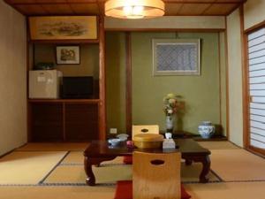 a living room with a table and a tv at Itoya Ryokan in Nanyo +60 photos