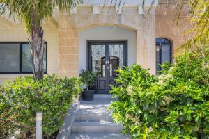 una puerta delantera de una casa con plantas en Luxurious Villa 5 BR, Pool, 3min from St Julian's en Is-Swieqi