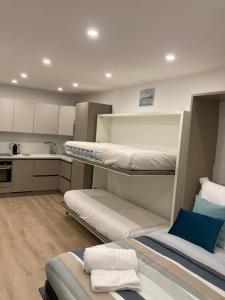 une chambre avec deux lits superposés et une cuisine dans l'établissement Studio La Cigale bord de mer, à Menton