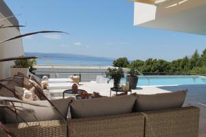 uma sala de estar com um sofá e uma piscina em Luxury Villa Hedone em Baska Voda