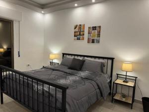 a bedroom with a black bed with two lamps at Alma Private Villa in Jerash