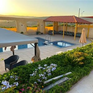 une terrasse avec une piscine, une table et des chaises dans l'établissement Alma Private Villa, à Jerash